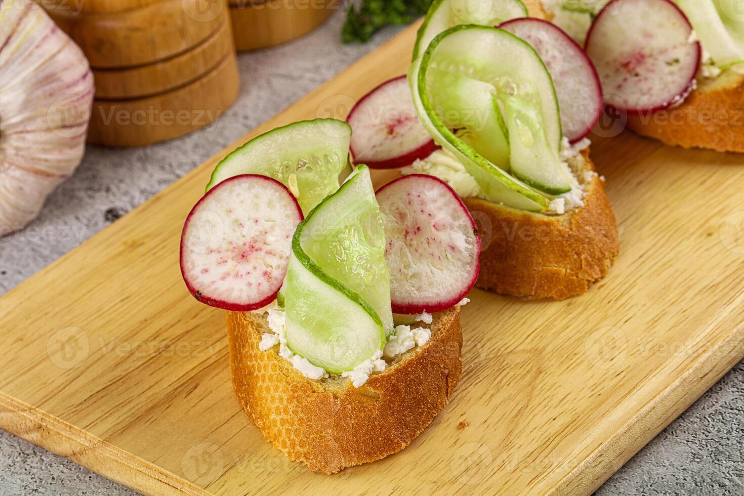 Two slices of bread with cucumbers and cheese on top photo