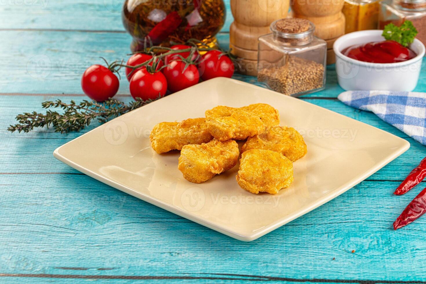 A plate with fried chicken and other ingredients on a blue table photo