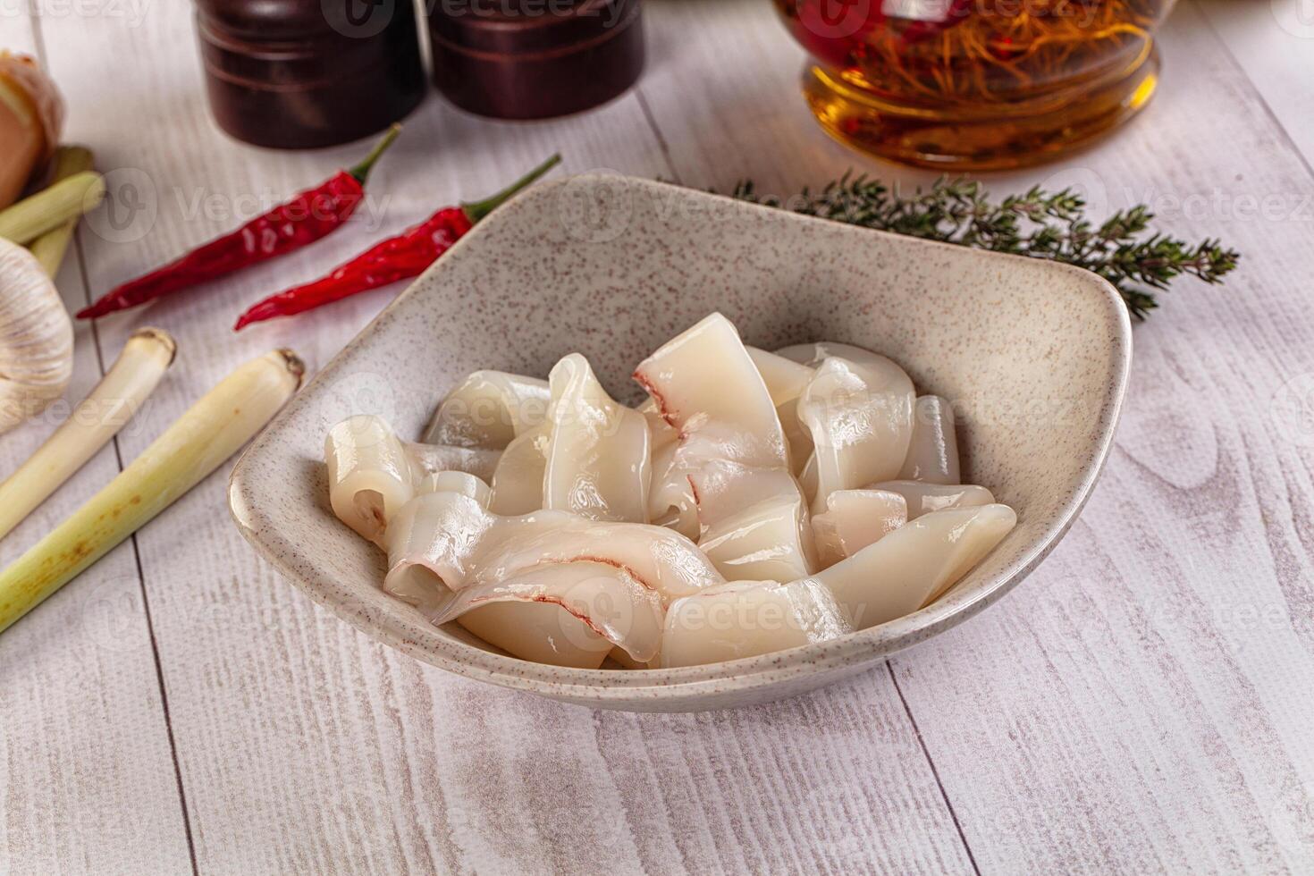 A bowl of sliced scallops on a table photo