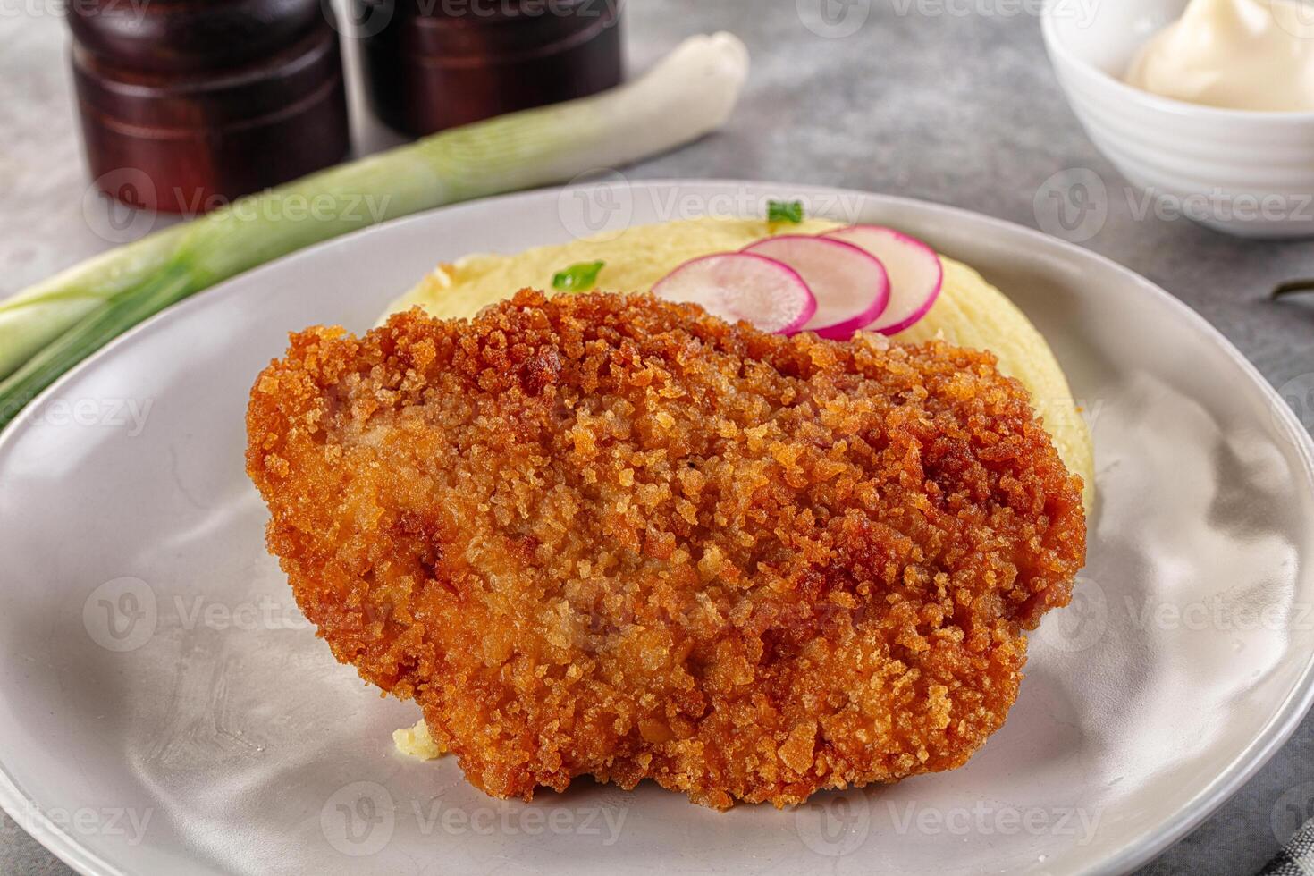 Fried chicken cutlet with pickles and onions on a plate photo