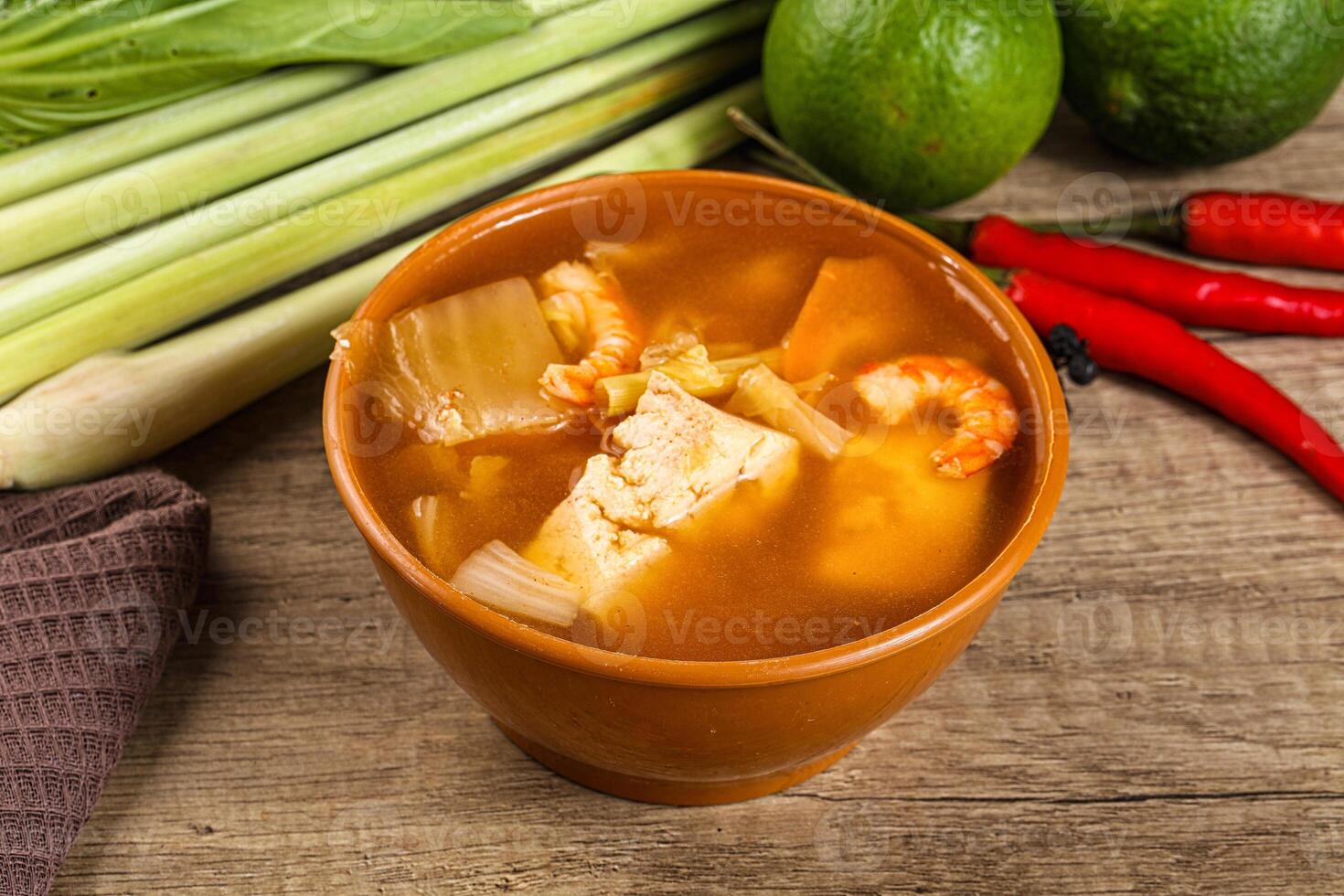 A bowl of soup with a green pepper and a lime photo