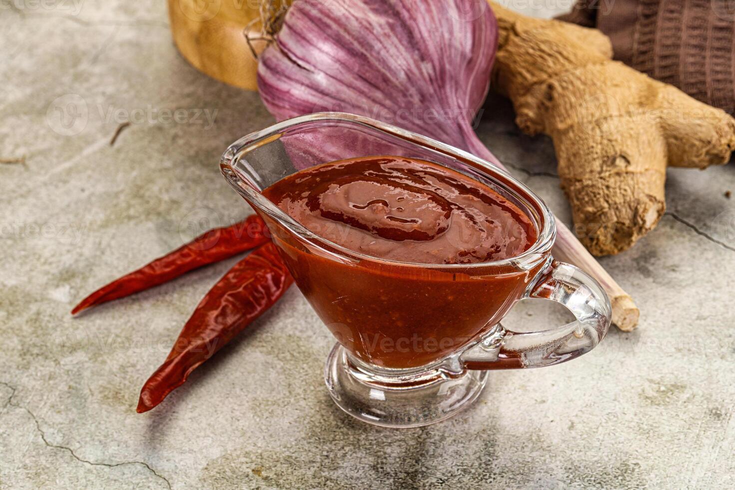 A glass jar with a sauce on a table photo