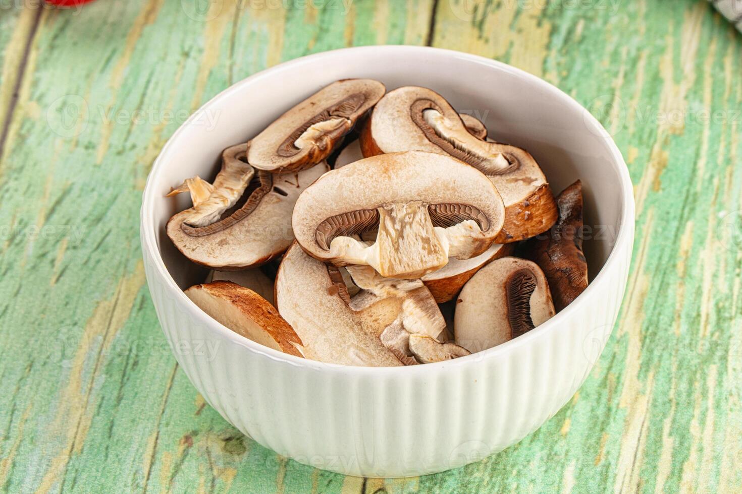 Mushrooms in a white bowl on a wooden table photo