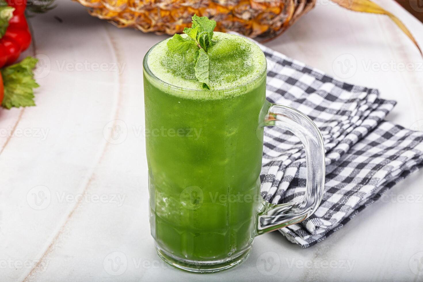 A green drink with a pineapple on top photo