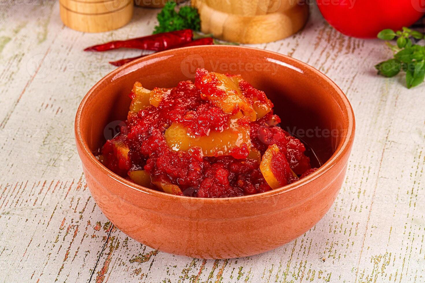A bowl of red sauce with peppers and spices photo