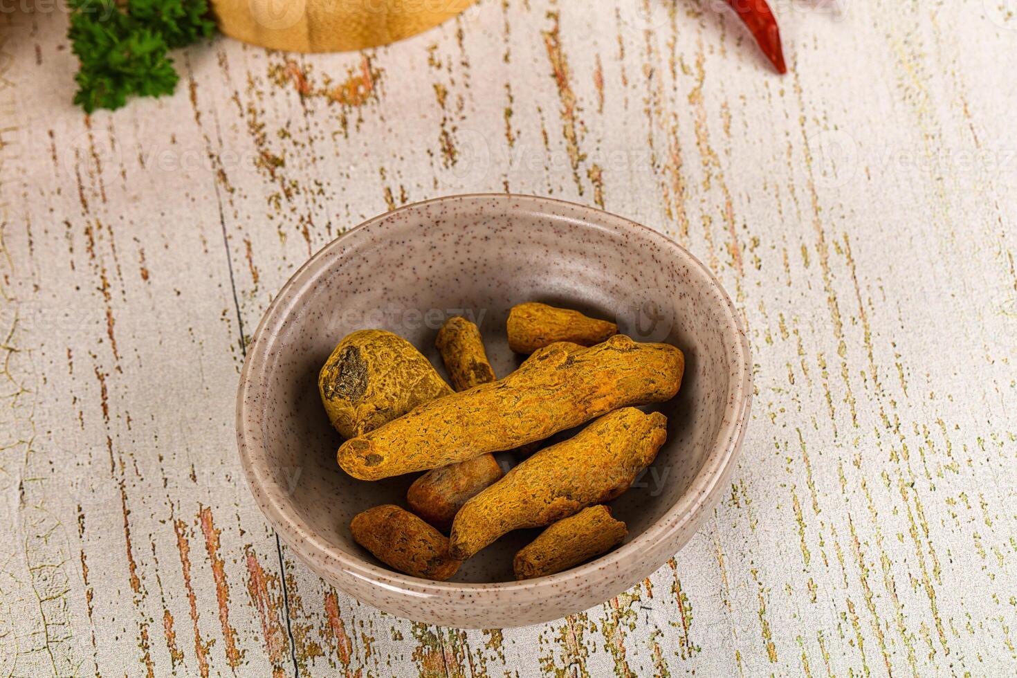 A bowl filled with yellow and green spices photo