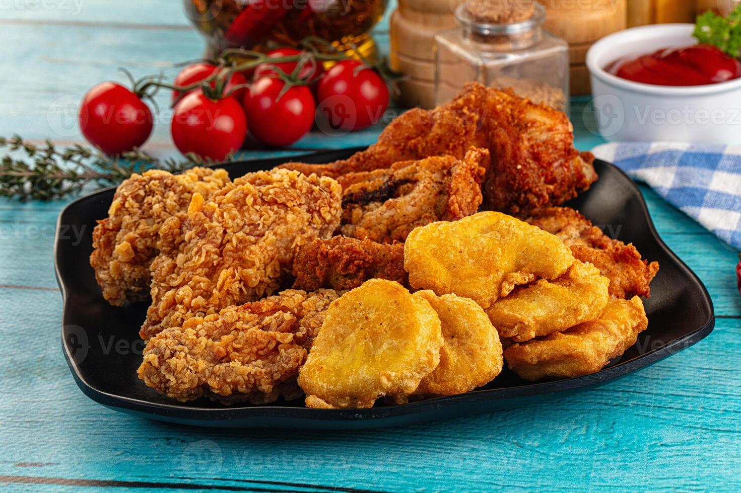 A plate of fried chicken and potatoes on a table photo