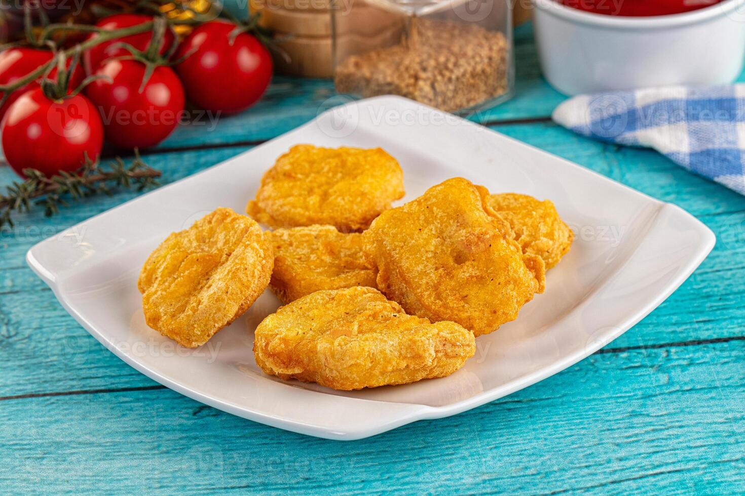 A plate of fried chicken nuggets on a blue table photo