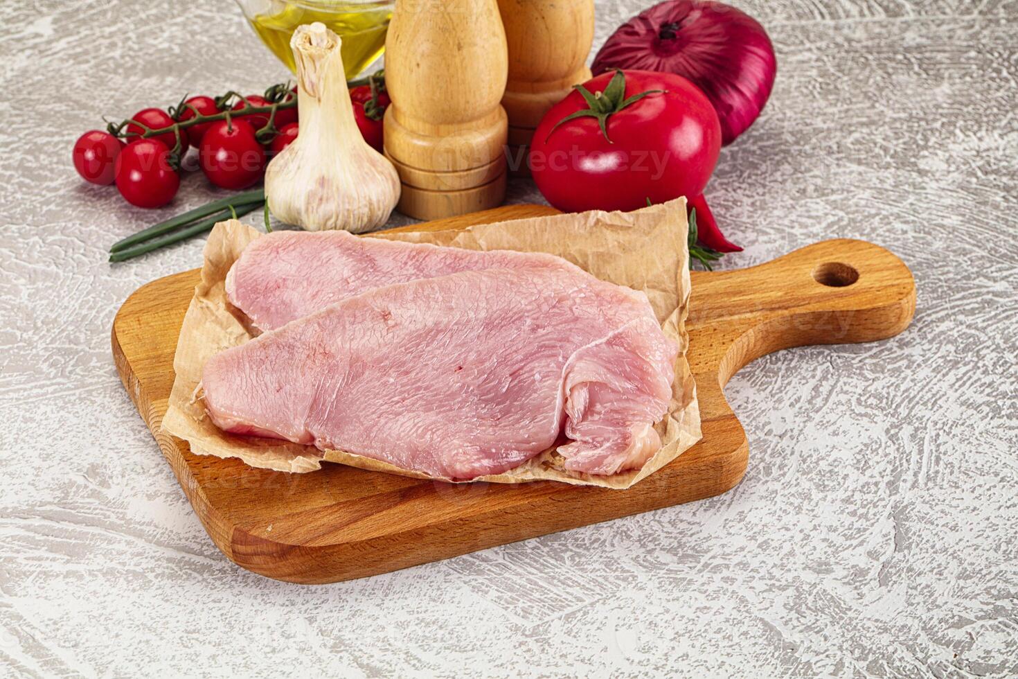 A cutting board with meat, vegetables and spices photo