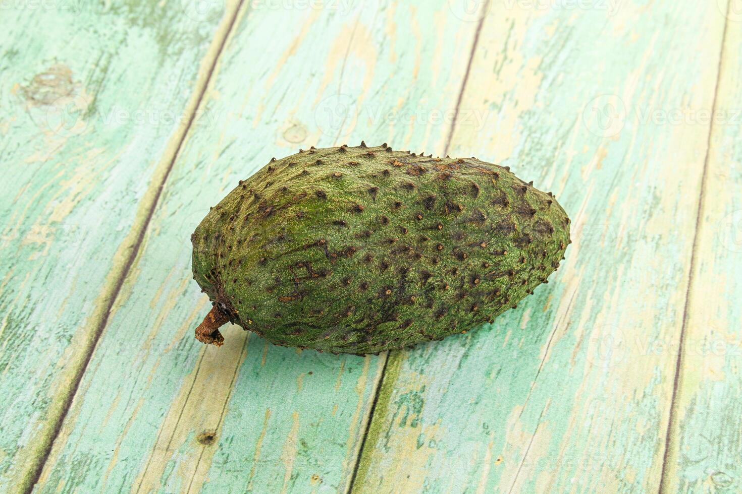 A single fruit is sitting on a wooden table photo