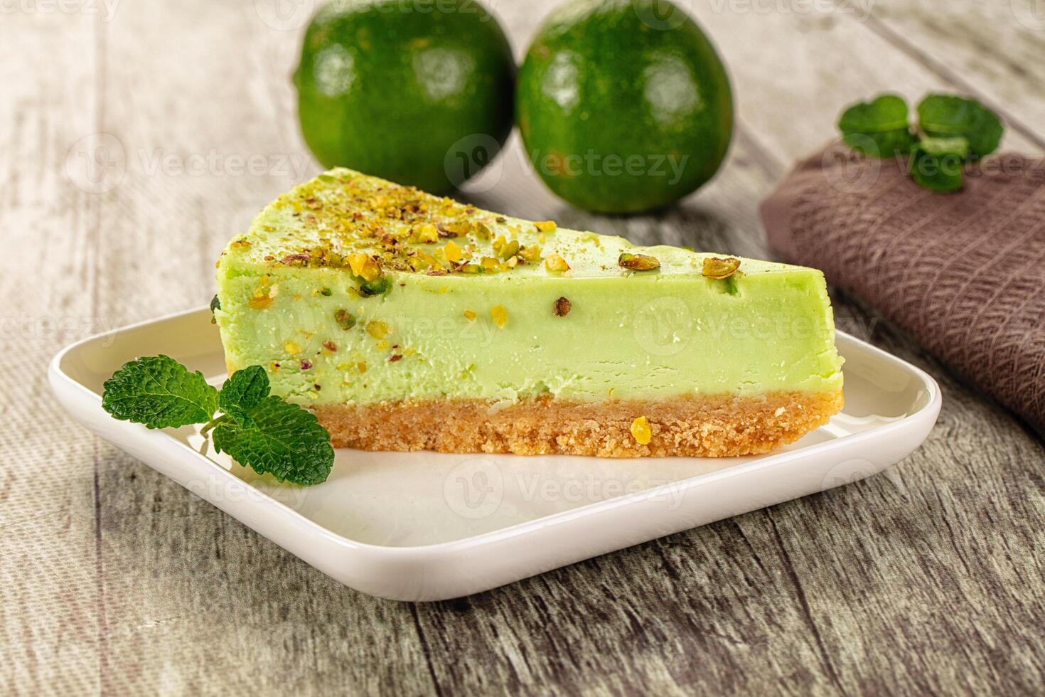 A piece of cake on a plate with two green avocados photo