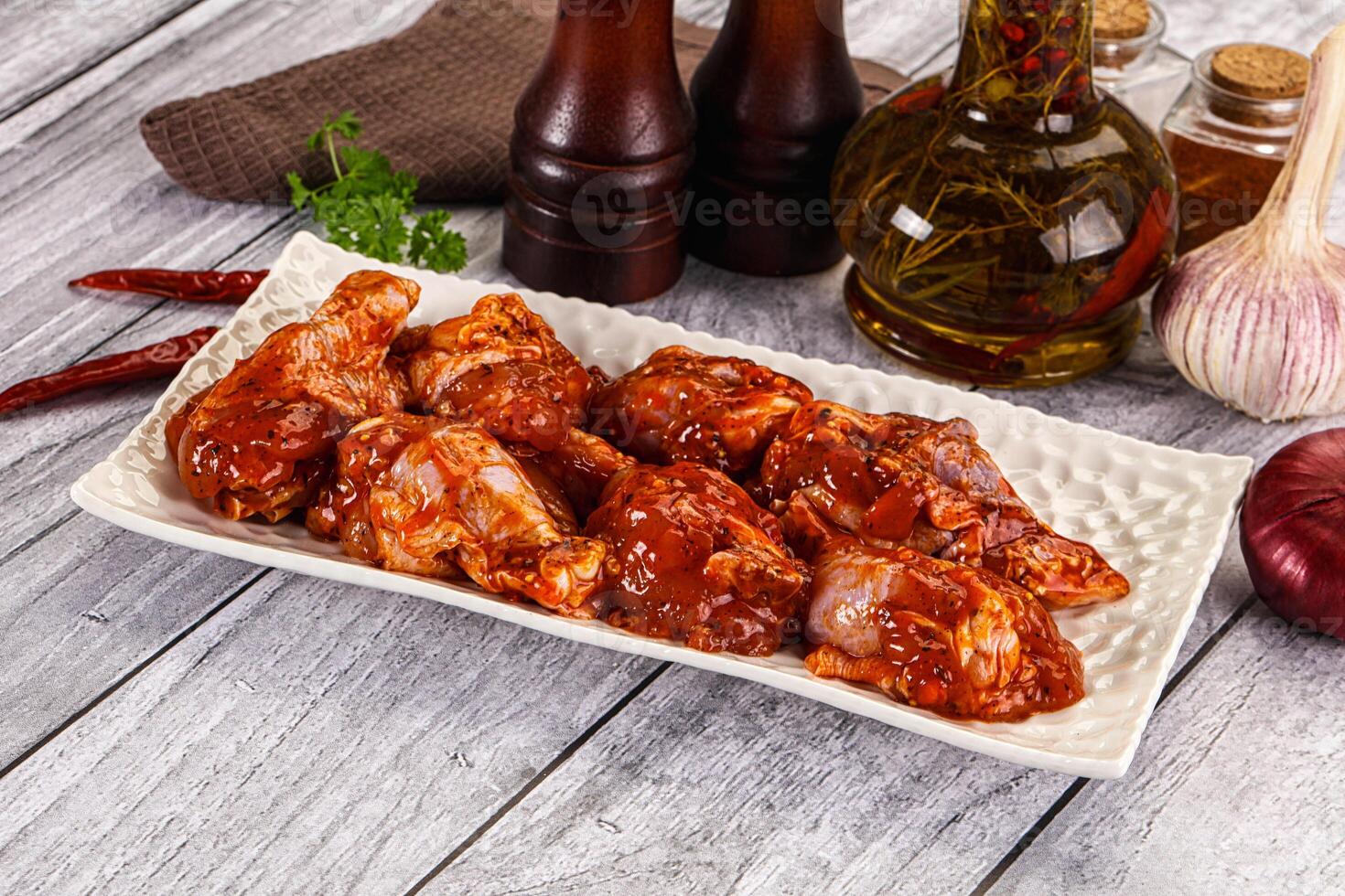 Chicken wings with sauce on a plate on a wooden table photo