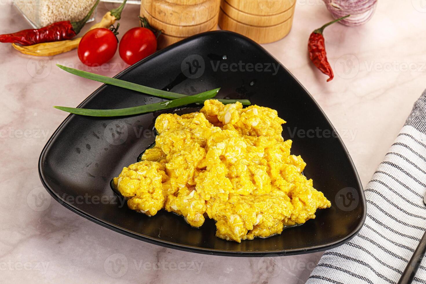A black bowl with scrambled eggs on it photo