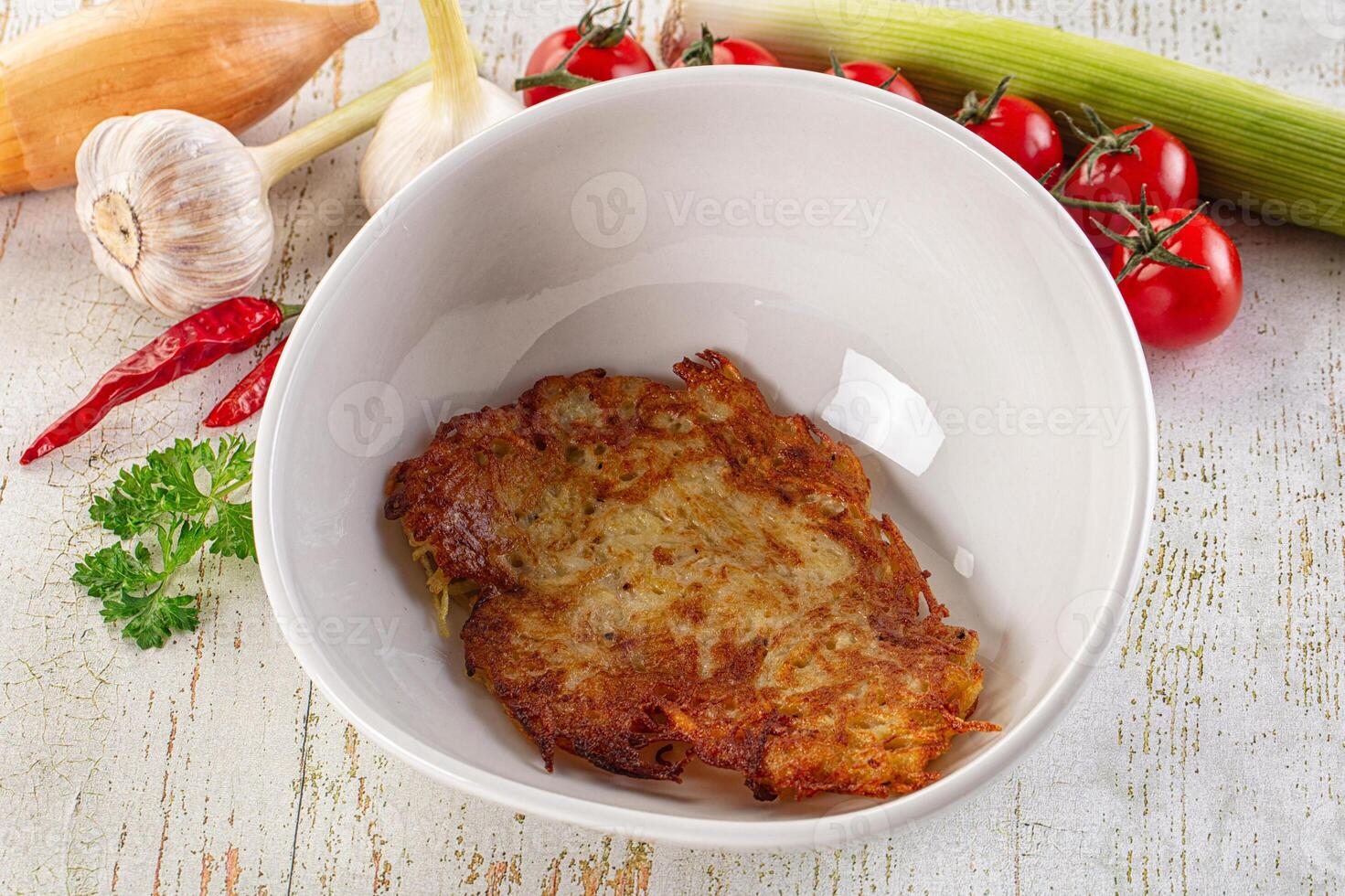 A bowl of food with vegetables and a piece of meat photo
