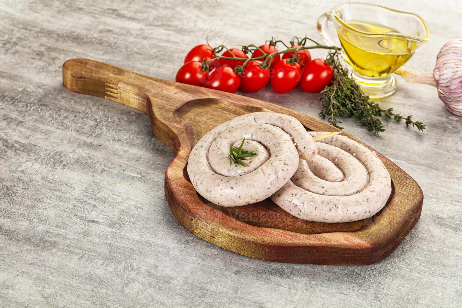 A wooden cutting board with sausage rolls on it photo