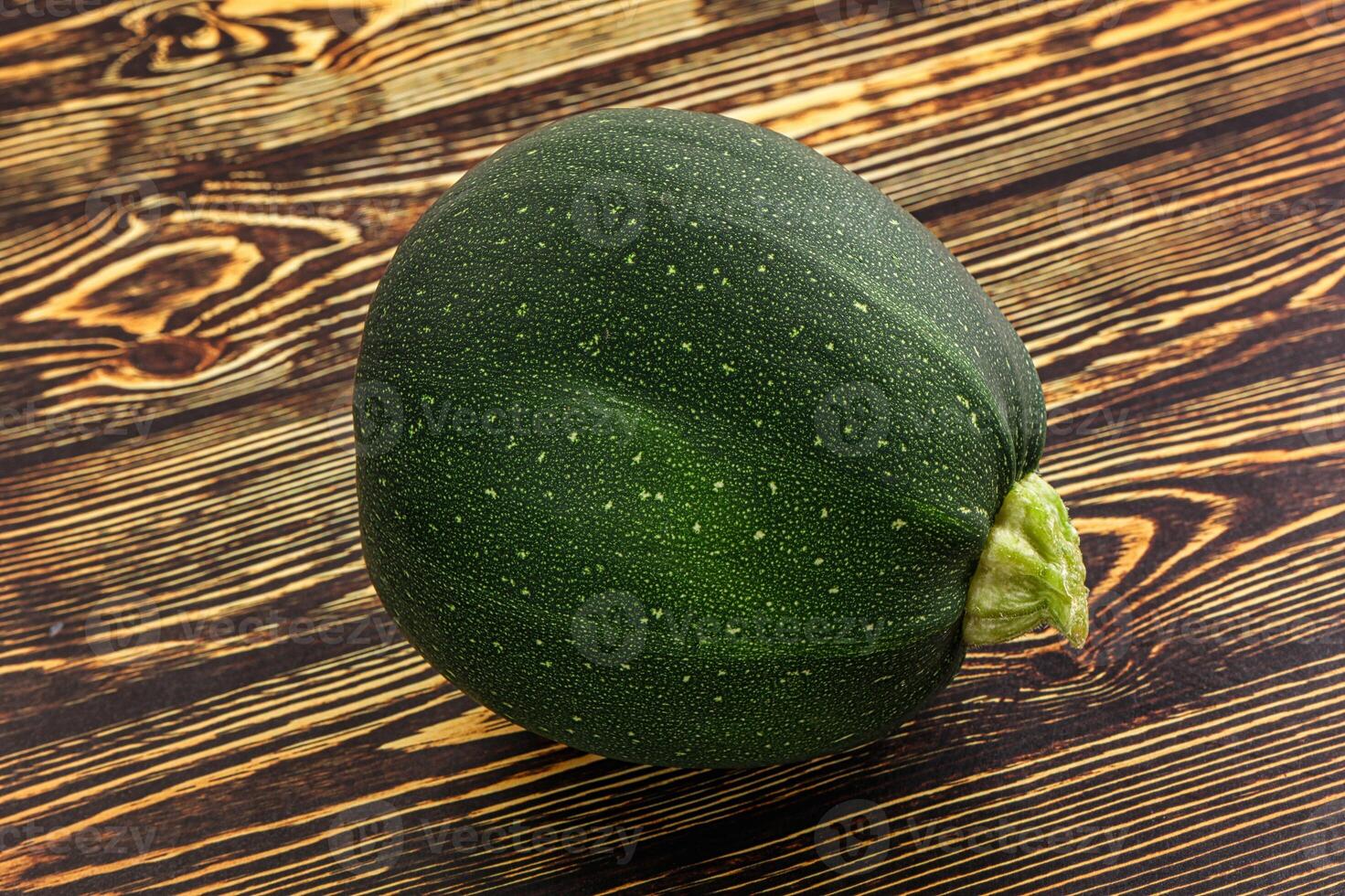 A green zucchini on a wooden table photo