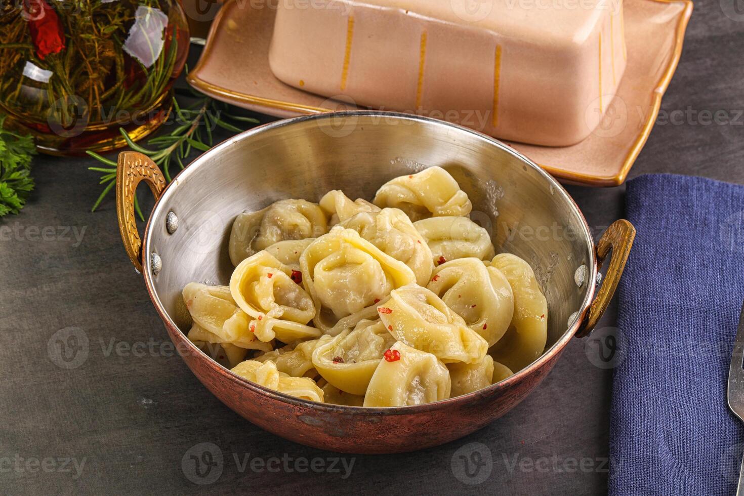 A bowl of pasta with a fork and knife next to it photo