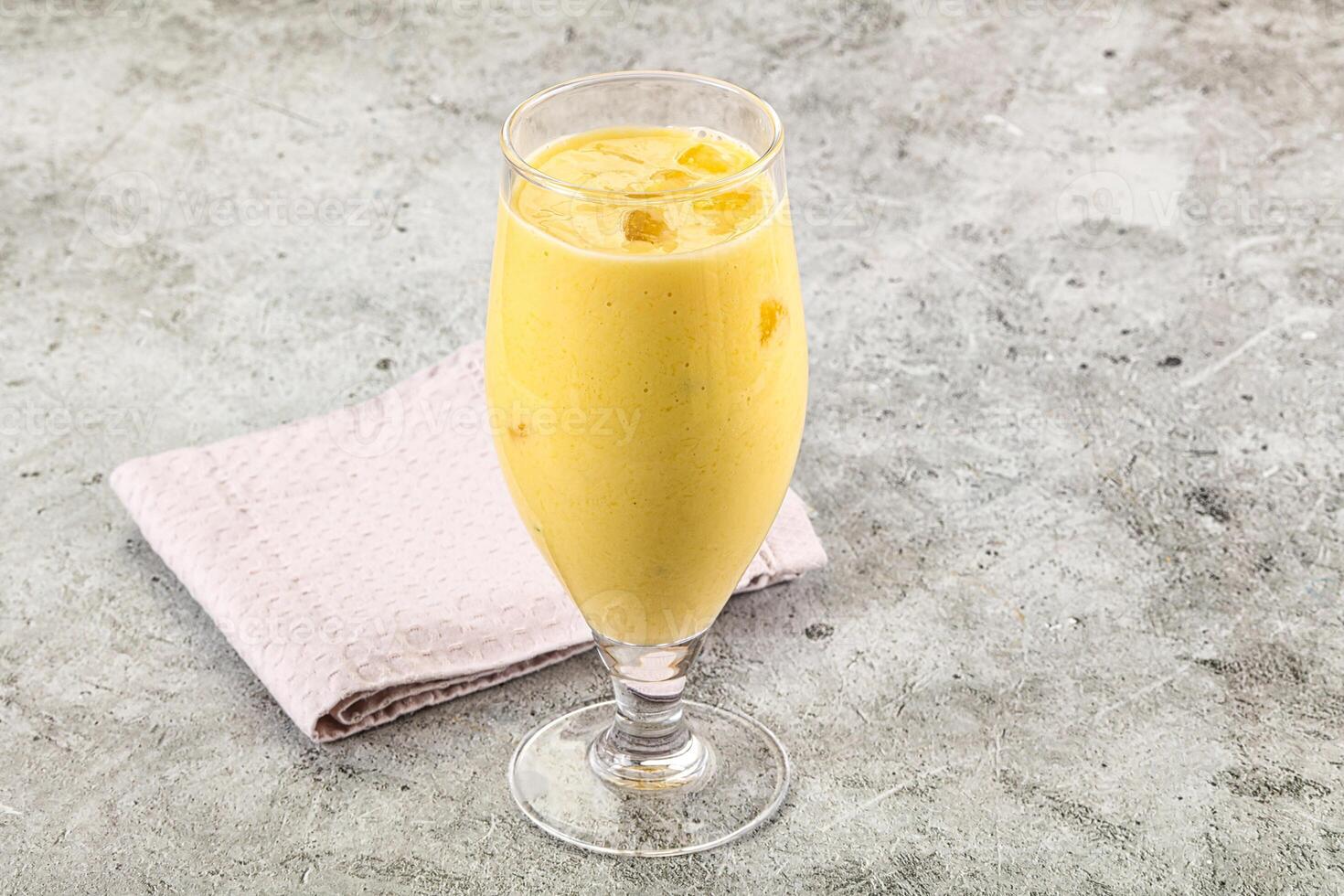A glass of orange juice with a napkin on the table photo