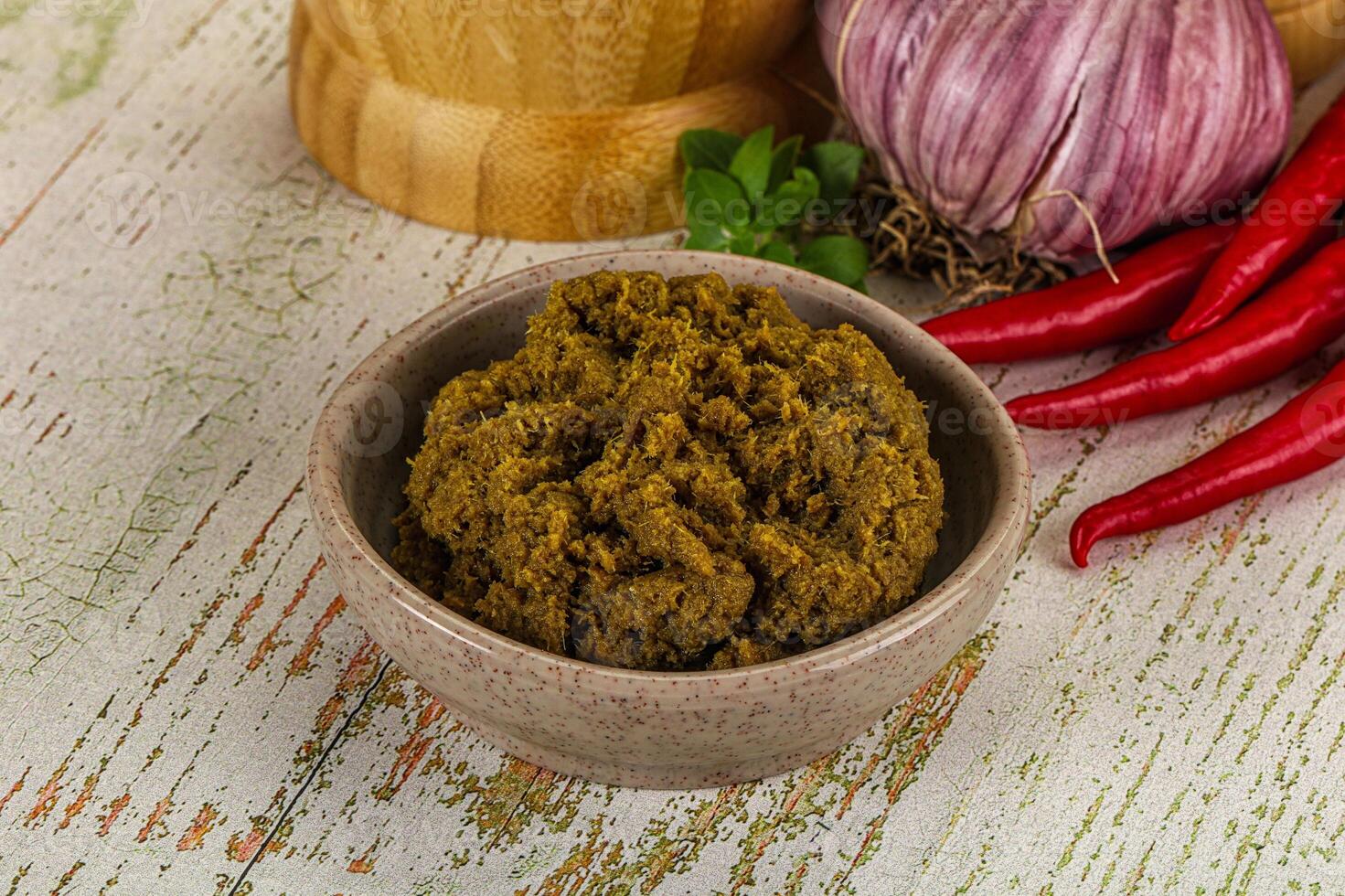 A bowl of spices and a wooden bowl with red peppers photo