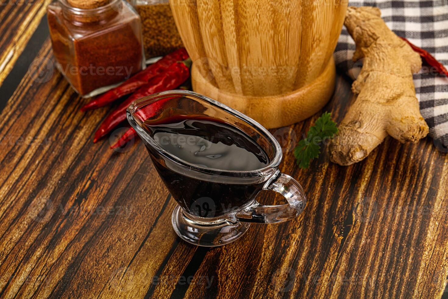 A wooden table with a glass of wine and spices photo