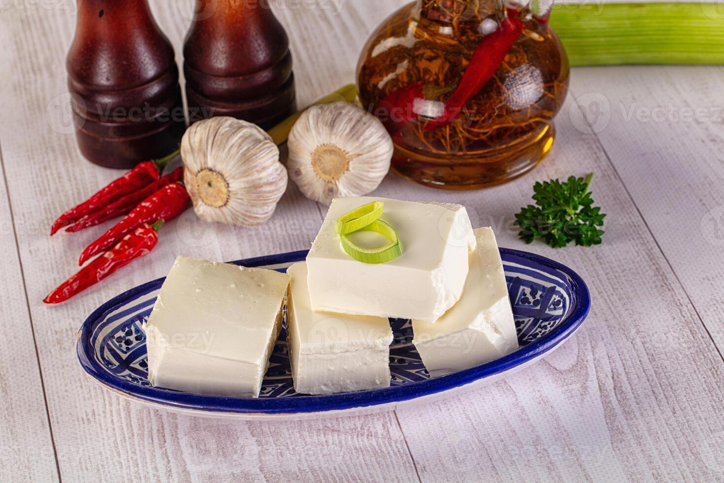 A plate of cheese, garlic, and other ingredients on a table photo