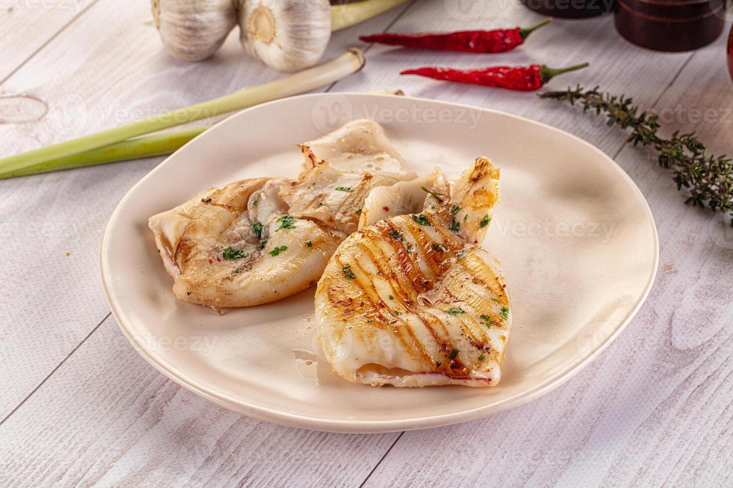 A plate of food on a table with a knife and a garlic clove photo