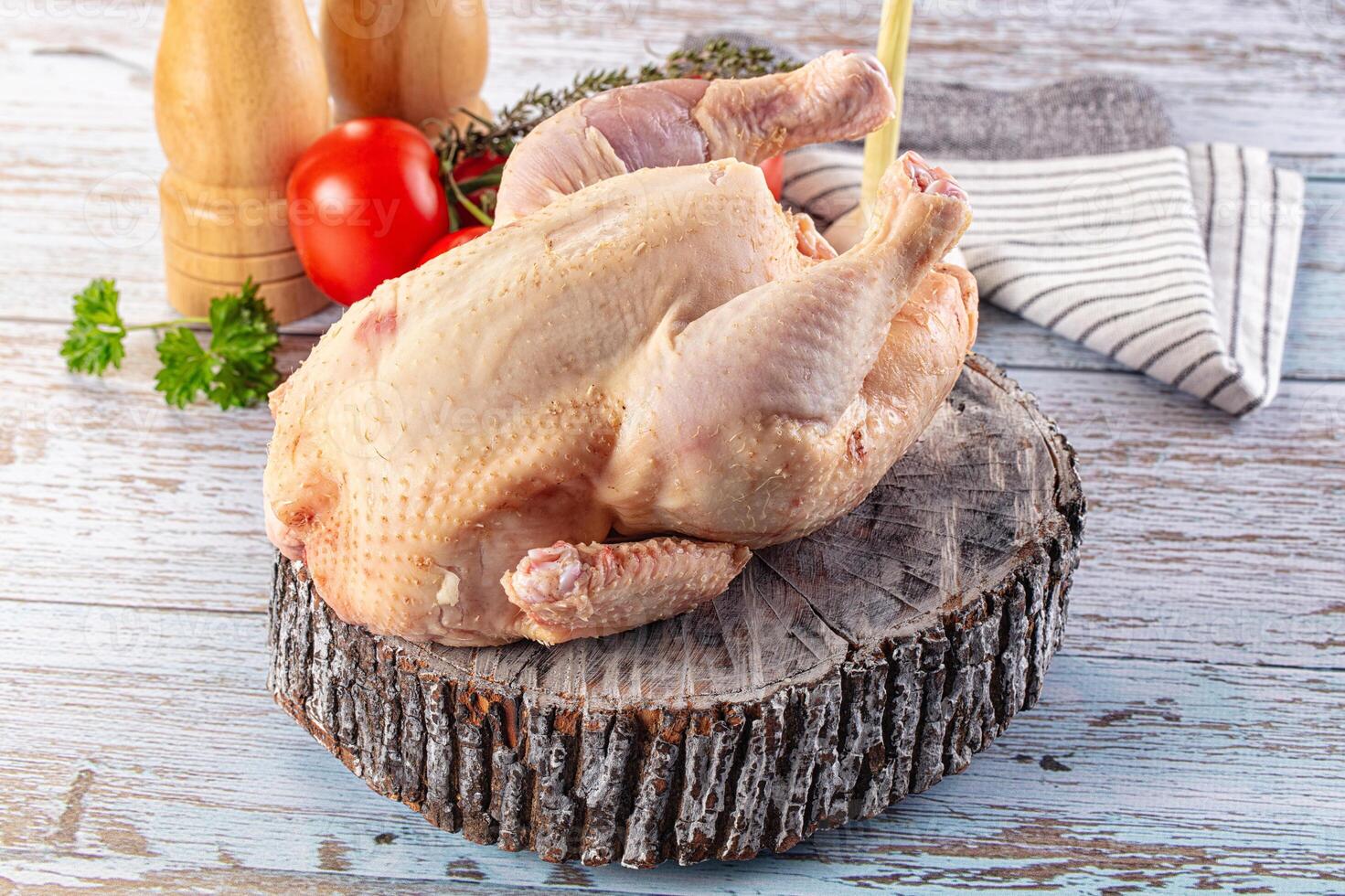 A chicken on a wooden table with a knife photo
