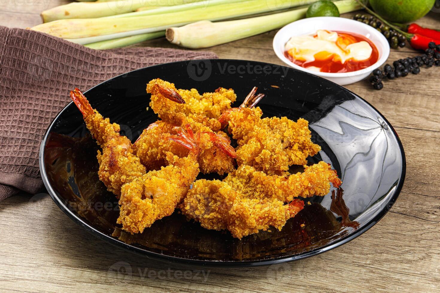 A plate of fried shrimp on a table with some other food photo