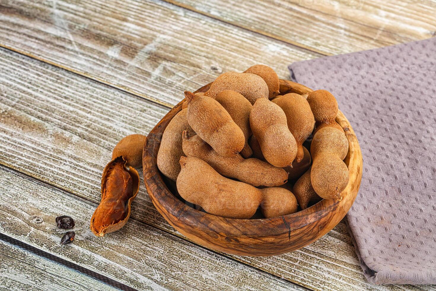 A wooden bowl filled with nuts and coffee beans photo