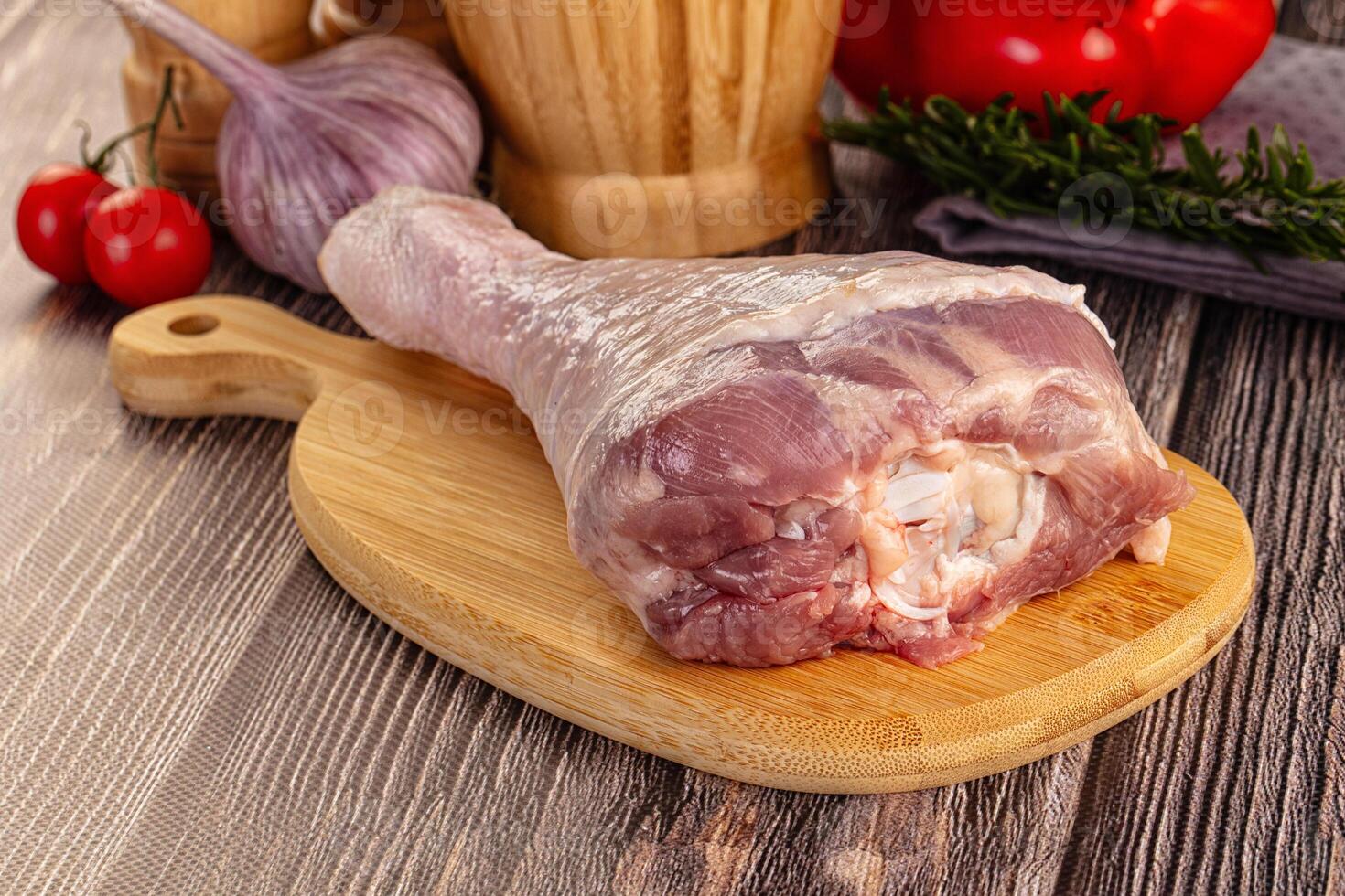 Raw turkey drumstick leg over board photo