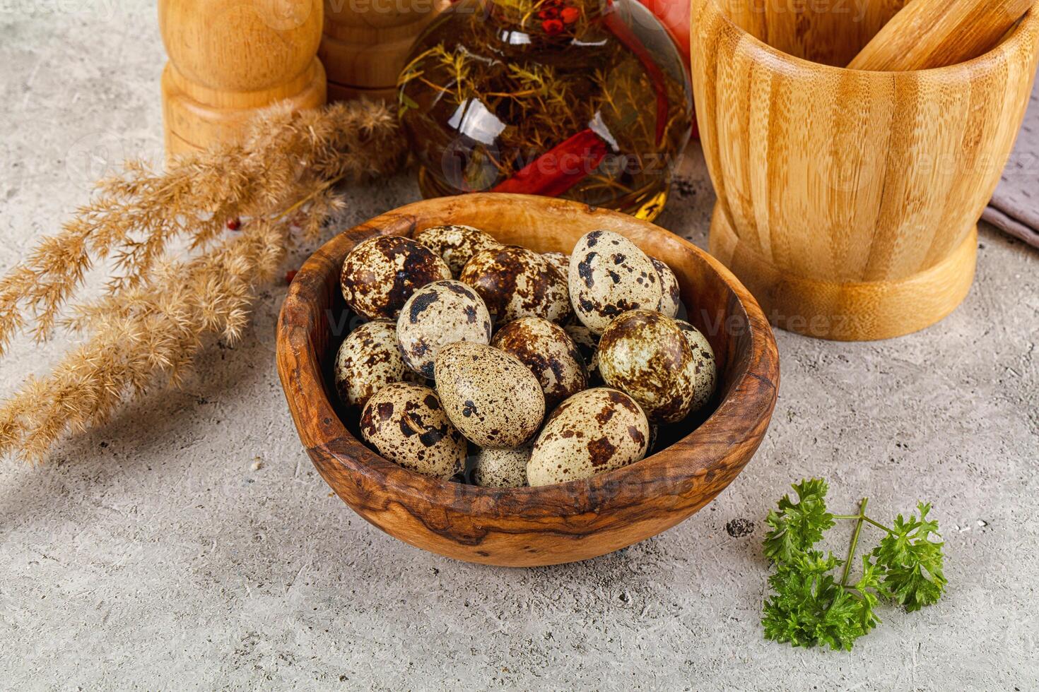 A bowl of quail eggs and herbs on a table photo