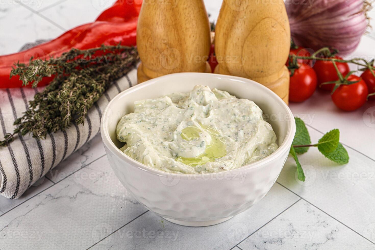 A bowl of dip with herbs and vegetables photo