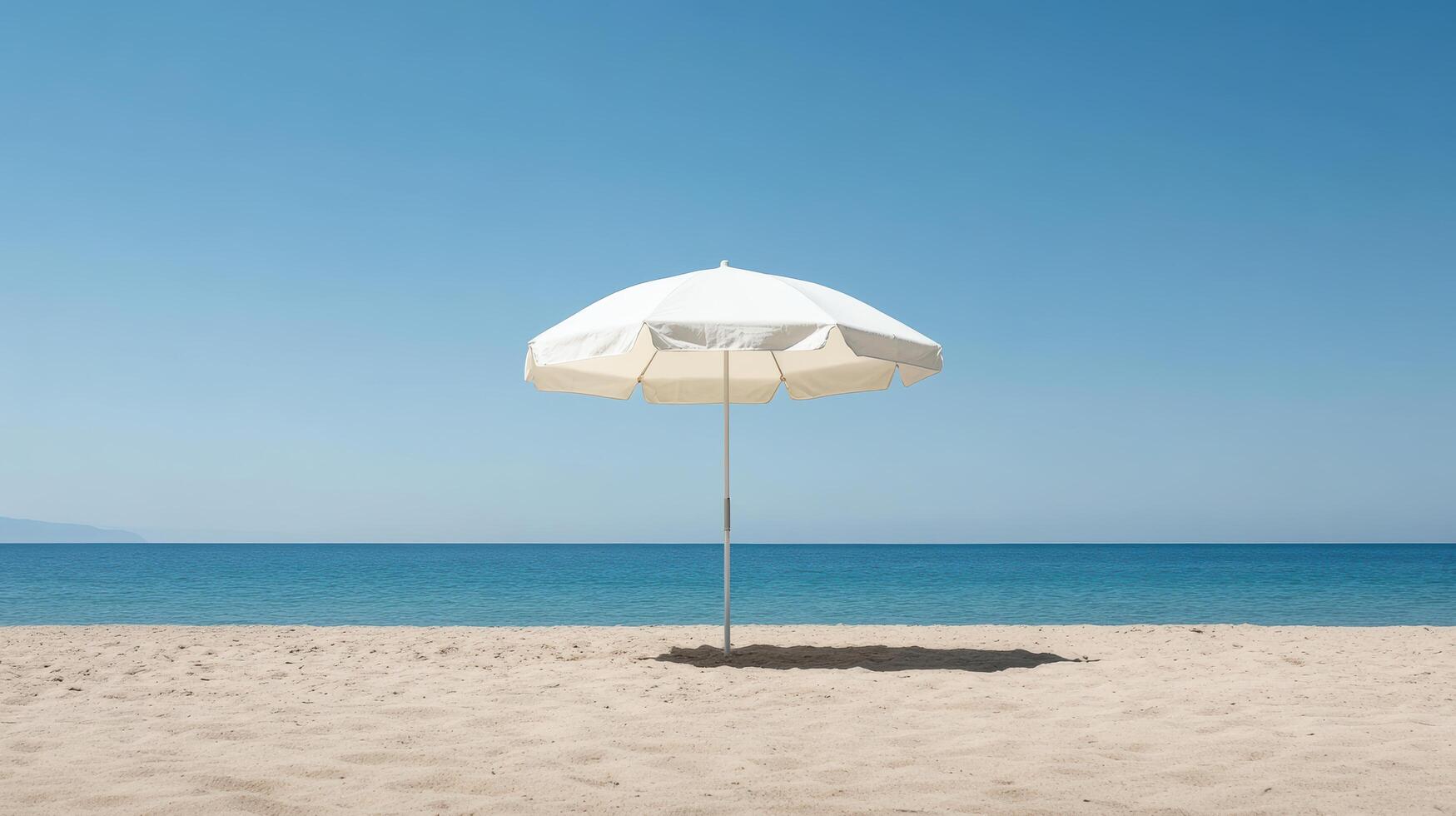 serene beach scene featuring white umbrella casting shadow on sand under clear blue sky photo