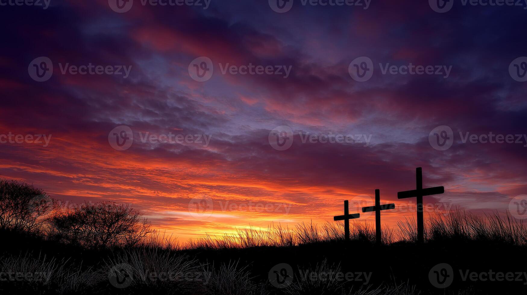Three crosses are silhouetted against a colorful sunset photo