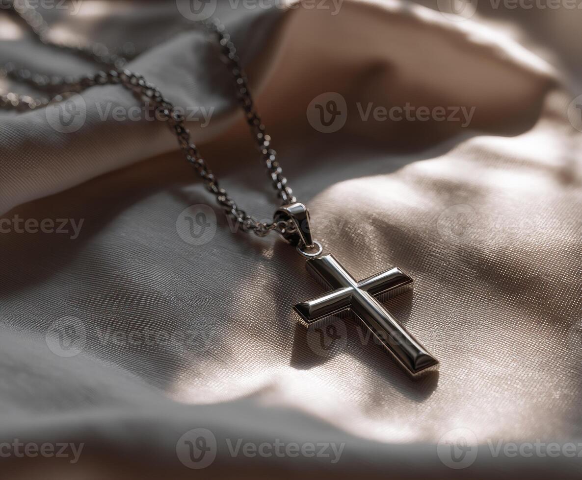 Silver cross necklace on smooth fabric surface photo