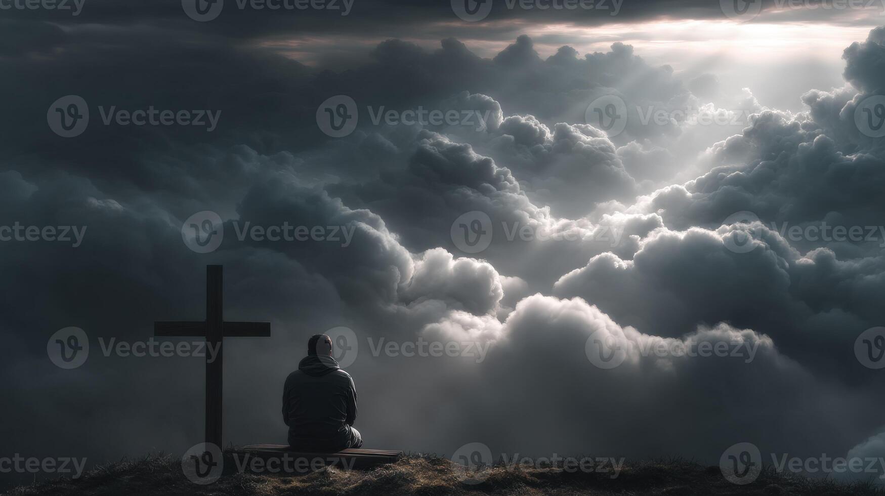 Man sitting on cross in the clouds photo
