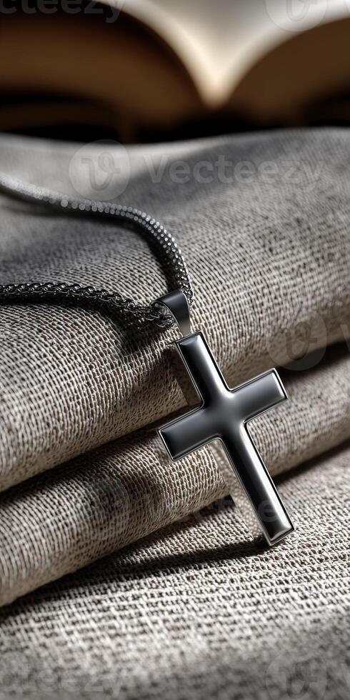 Elegant black cross pendant resting on textured fabric photo