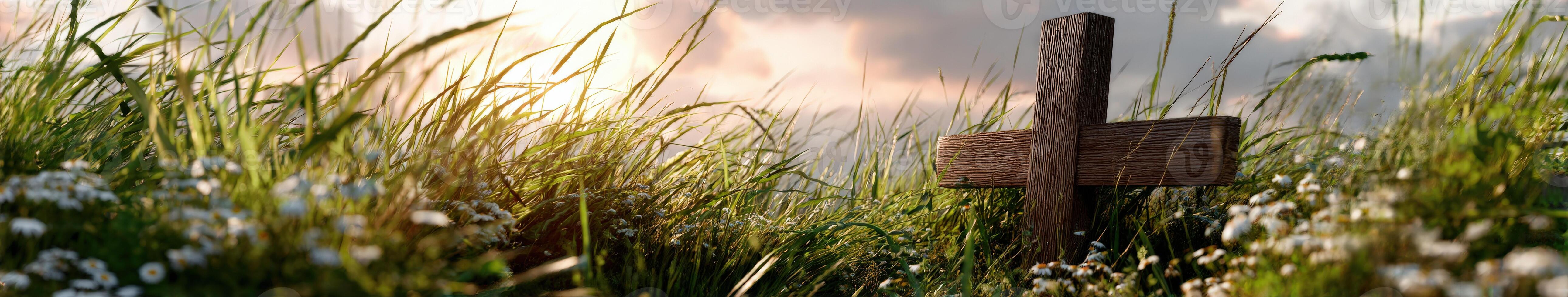 Wooden cross in a grassy field during sunset photo