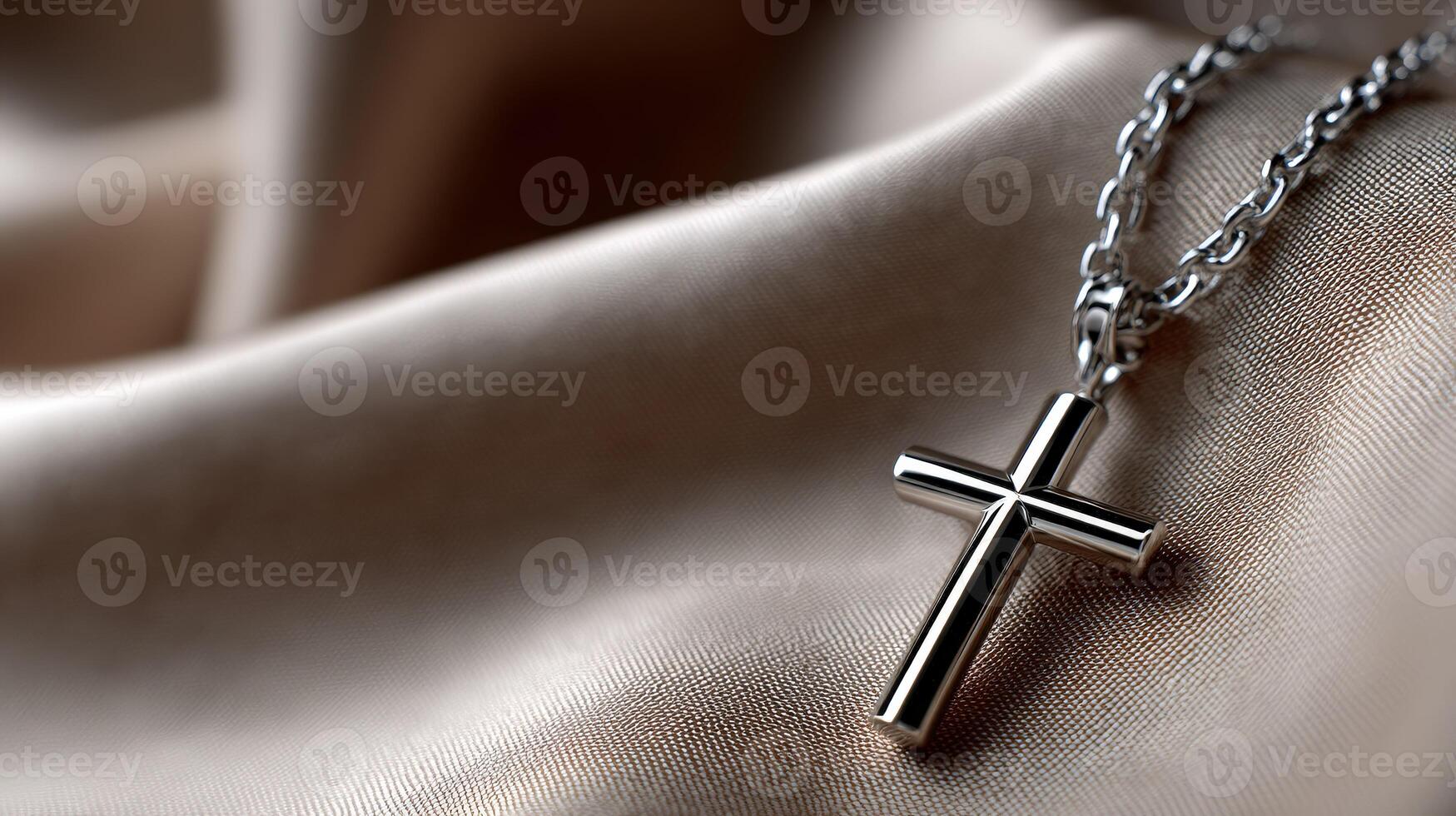 A silver cross necklace on a beige background photo
