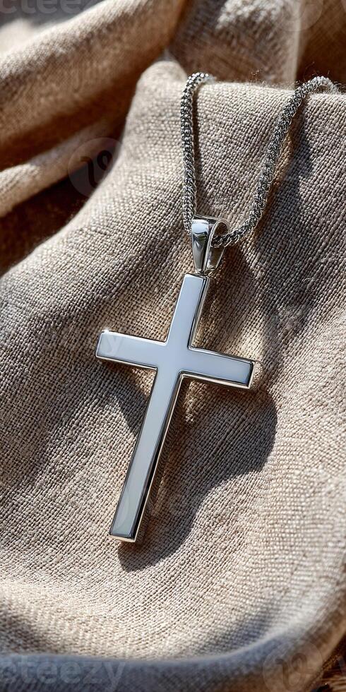 A silver cross pendant on a linen cloth photo