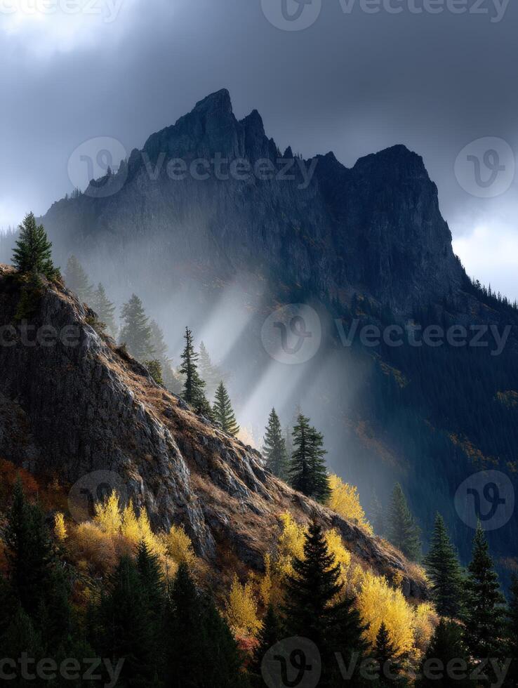 Mountains with trees and sunbeams shining through the clouds photo