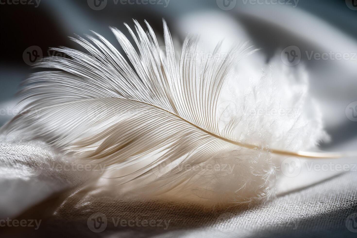 Delicate white feather resting on soft fabric surface photo