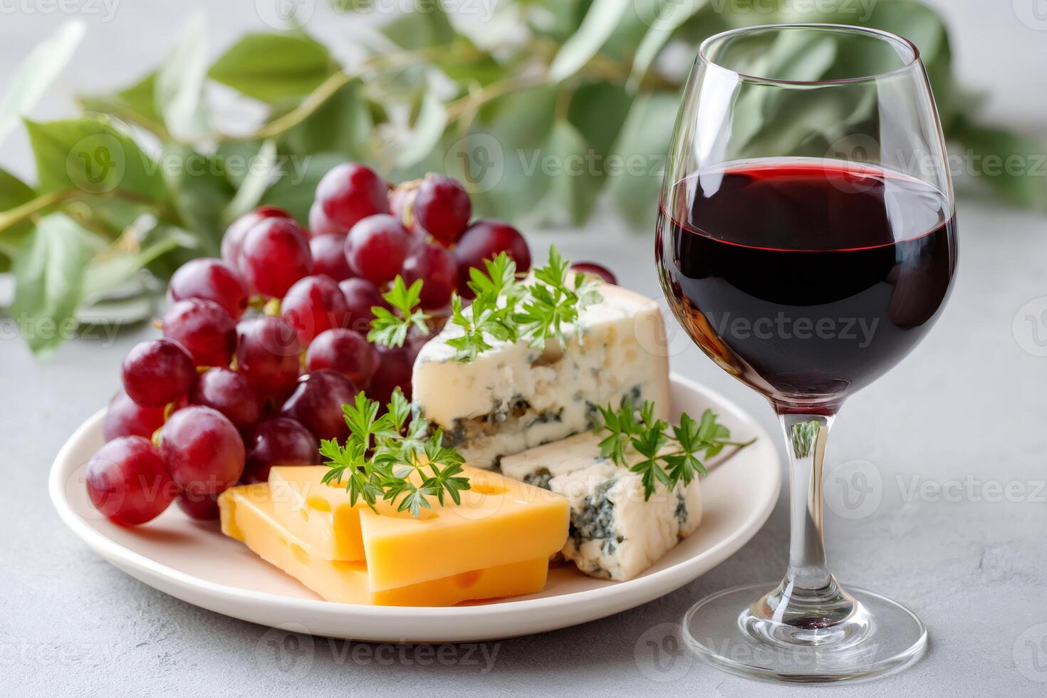 Glass of red wine served with various cheese and grapes photo