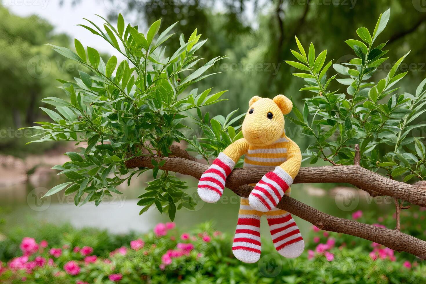 Yellow knitted monkey toy relaxing on a tree branch in a peaceful garden photo