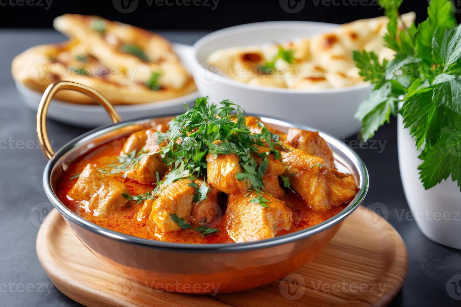Chicken tikka masala garnished with coriander served with naan bread and rice photo