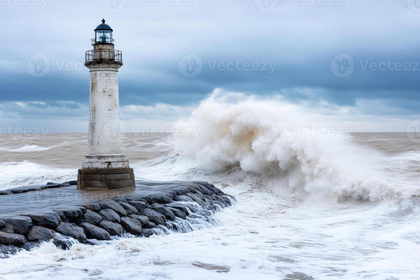 White lighthouse facing powerful ocean waves during storm photo