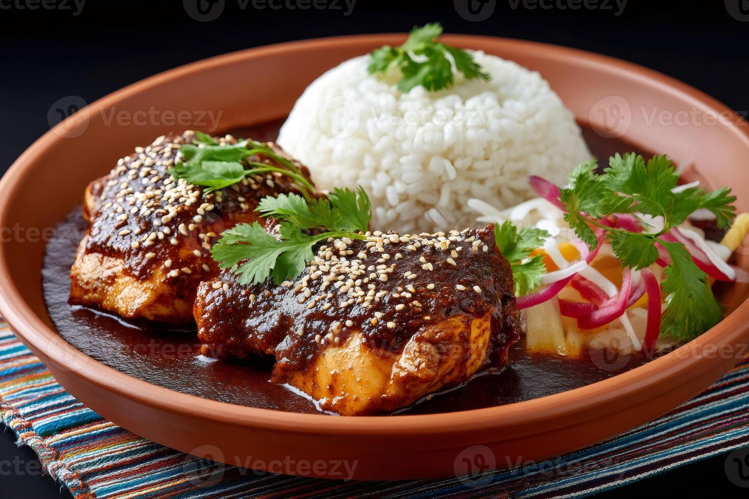 Chicken in mole poblano sauce with rice and salad garnished with sesame seeds and coriander photo