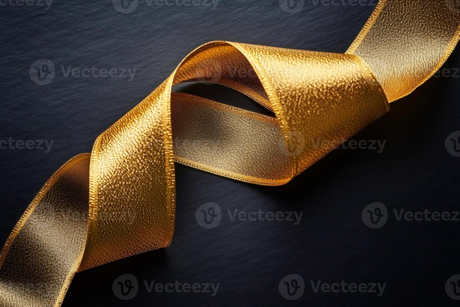 Golden ribbon swirling on dark background creating elegant composition photo