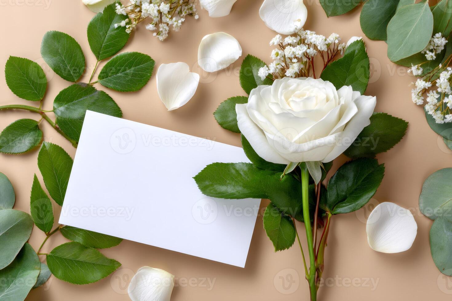White rose with gypsophila and blank invitation card is lying on beige background photo
