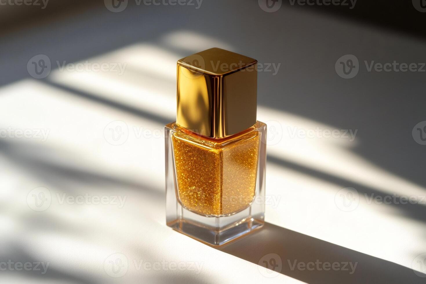 Golden nail polish bottle reflecting sunlight on white surface photo